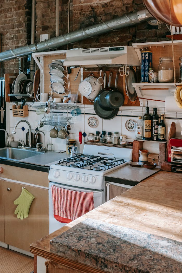 Services-01 Masonry kitchen furnished with rustic kitchen units and filled with many kitchenware and utensils in sunlight